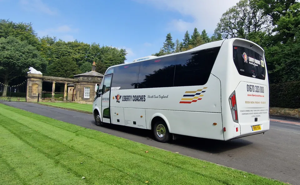 White Liberty Coaches coach viewed from the rear beside a grass verge
